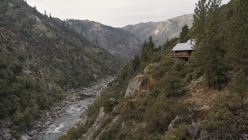 Mariposa County, California: Steep pine/oak/manzanita canyon; cabin with metal roof on the slope; river canyon below
