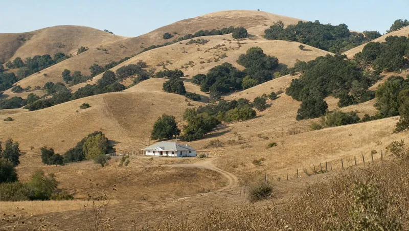 San Benito County, California: Rolling golden hills with oaks and chaparral; ranch house on a dirt road
