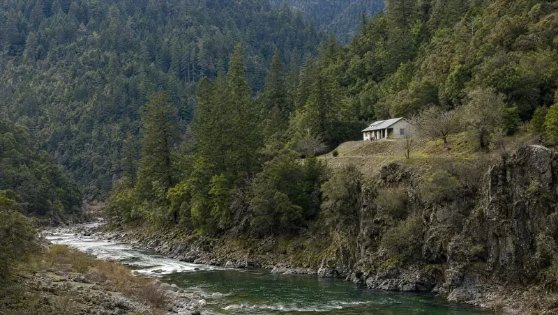 Trinity County, California: Steep fir/oak mountains, clear river in the canyon; small rural home on a bench above the river